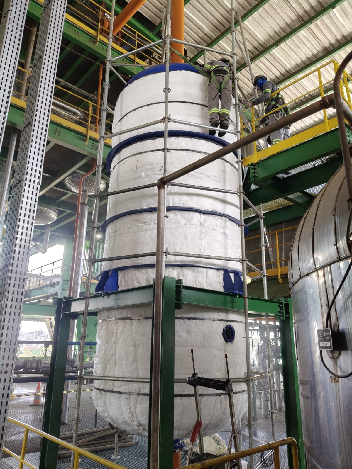Isolamento térmico em vaso vertical com equipe em altura