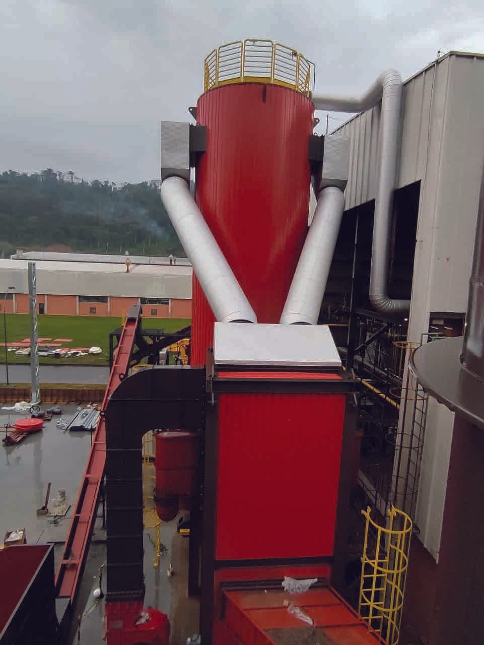 Ciclone industrial com tubulações isoladas em planta de papel e celulose