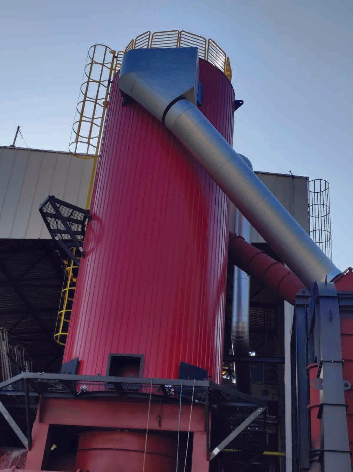 Silo vertical pintado com duto inclinado em planta industrial