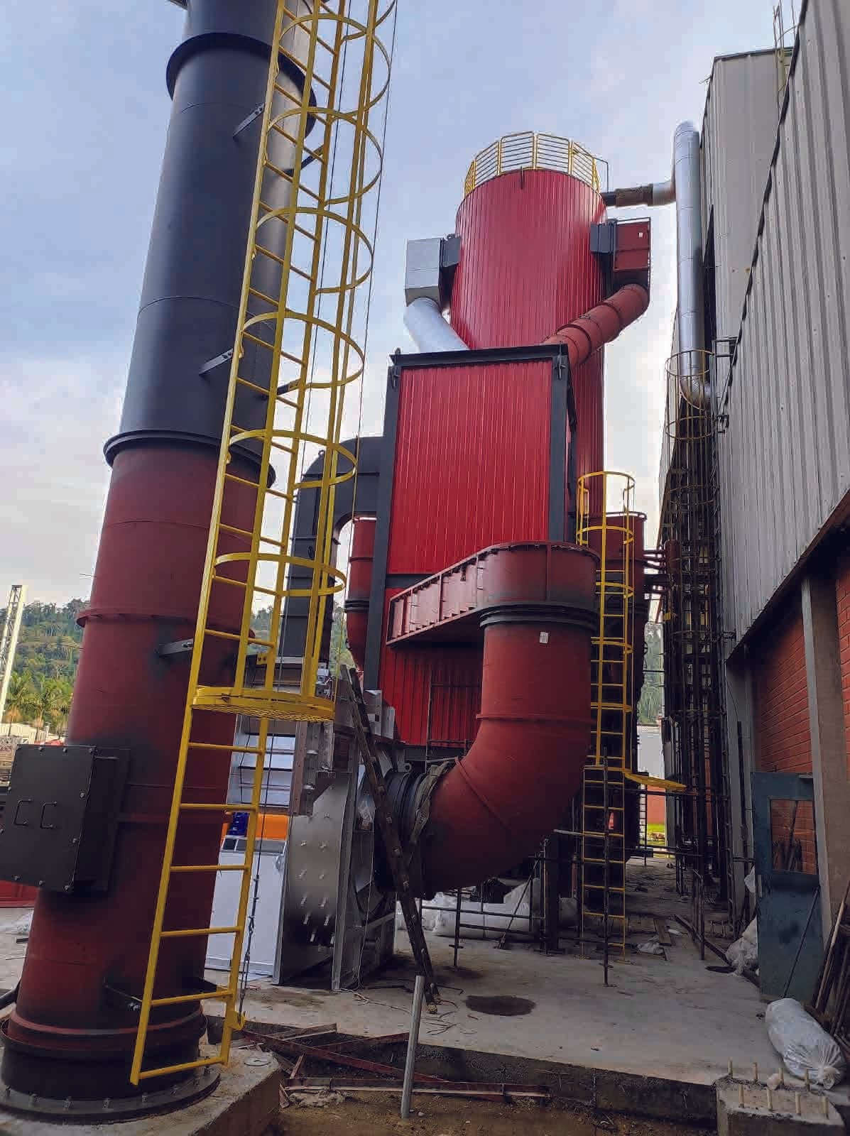 Ciclones e dutos verticais em planta industrial com acessos em escada