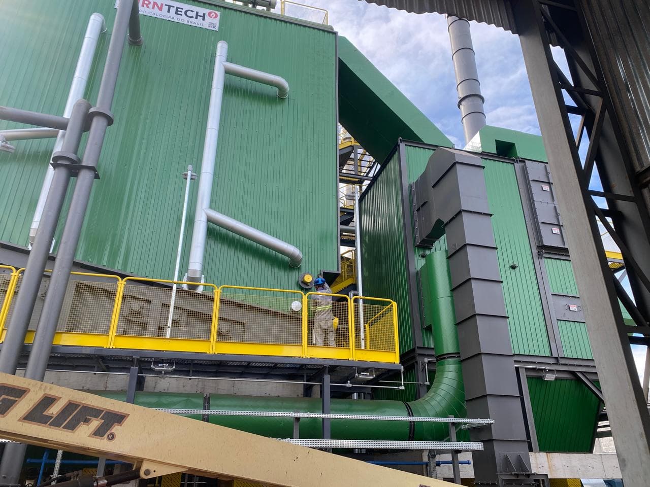 Equipe Sigma em operação com plataforma elevatória em planta industrial